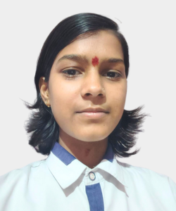 Portrait of a young woman with short black hair, wearing a white shirt with blue trim and a red bindi on her forehead, neutral background.