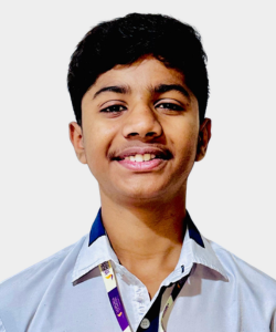 Smiling student wearing a light blue school shirt and a lanyard, posed against a light background.