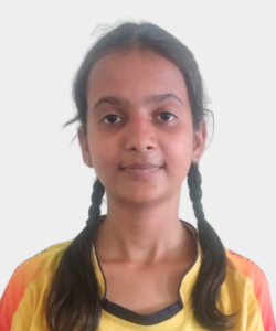 Portrait of a young girl with two braids, wearing a yellow-orange shirt, facing the camera.